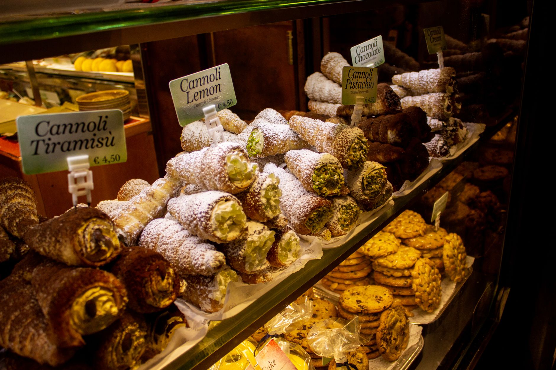 Comptoir d'un café italien avec vitrine de pâtisseries.