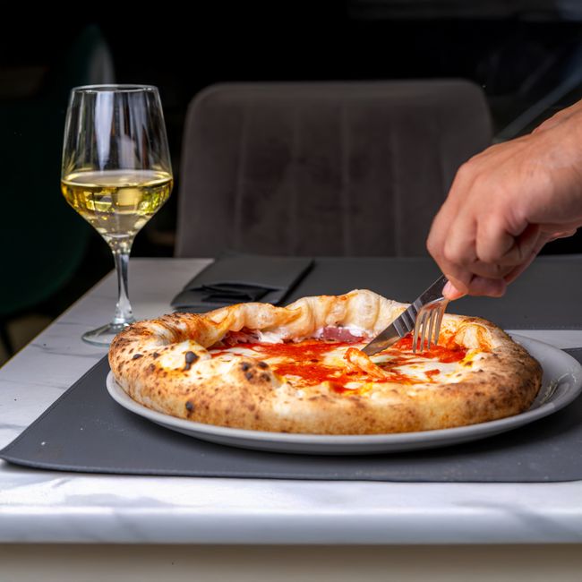 Gros plan d'une part de pizza napolitaine, fromage fondant.